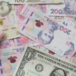 Cédulas de diferentes moedas, incluindo uma nota de dólar, em close e parcialmente desfocadas.