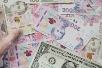 Cédulas de diferentes moedas, incluindo uma nota de dólar, em close e parcialmente desfocadas.