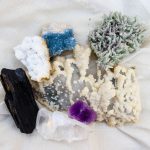 Diversas amostras de minerais, incluindo ametista e quartzo, dispostas para observação.